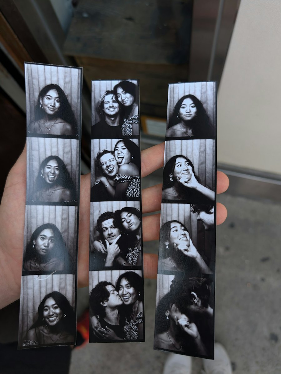 Hand holding black and white photo booth strips